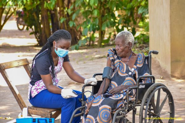 nurse treating older woman in wheelchair