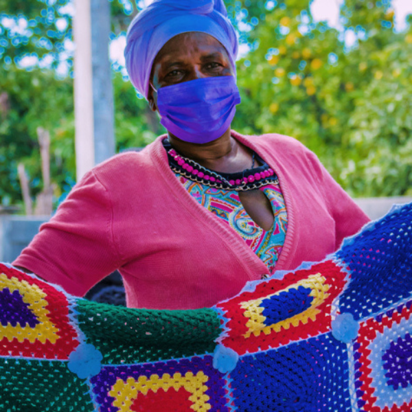 Grandmother holding colourful quilt. MASO in Zimbabwe.