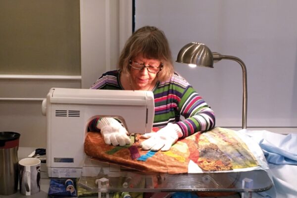 woman at a sewing maching working on the quilt