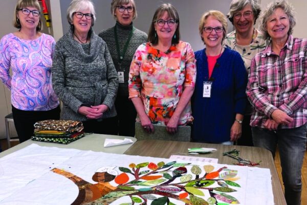 women psong with the quilt on a table