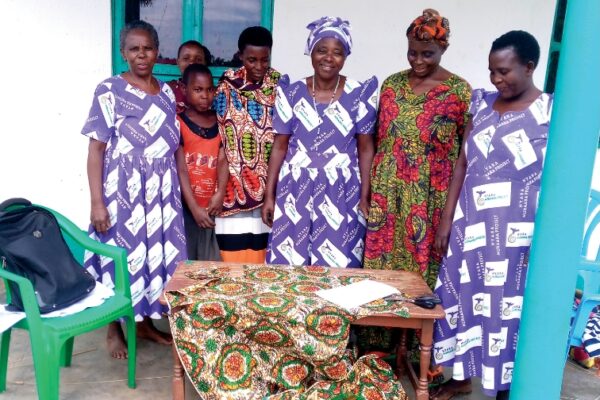 women posing with a section of quilt