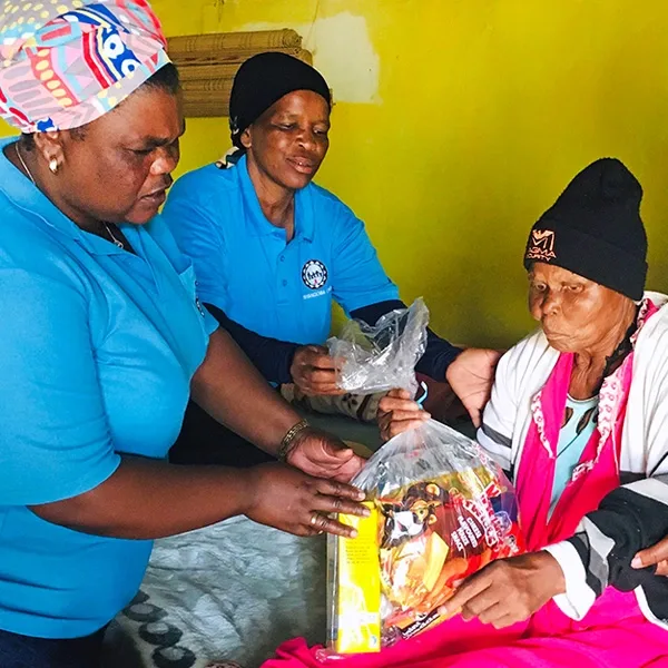 Community health workers providing assistance to a woman.