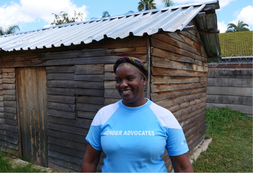 woman smiling and wearing a light blue gender advocates shirt